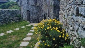 A stone building with a wooden door and steps leading up to it. - La Casa Di Edy (Prato)