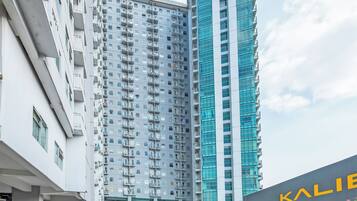 A multi-story building with balconies and a large glass facade.