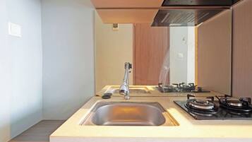 A modern kitchen with a built-in sink, a stove, and a mirror above the countertop.