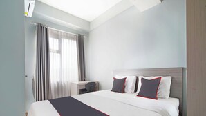 Ein Hotelzimmer mit einem großen Bett, einem Schreibtisch und einem Sessel.