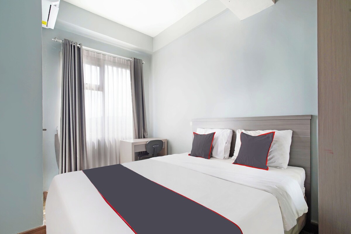 Una habitación de hotel con una cama grande, un escritorio y una silla.