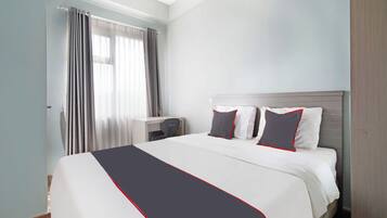 A hotel room with a bed, a desk, and a chair.