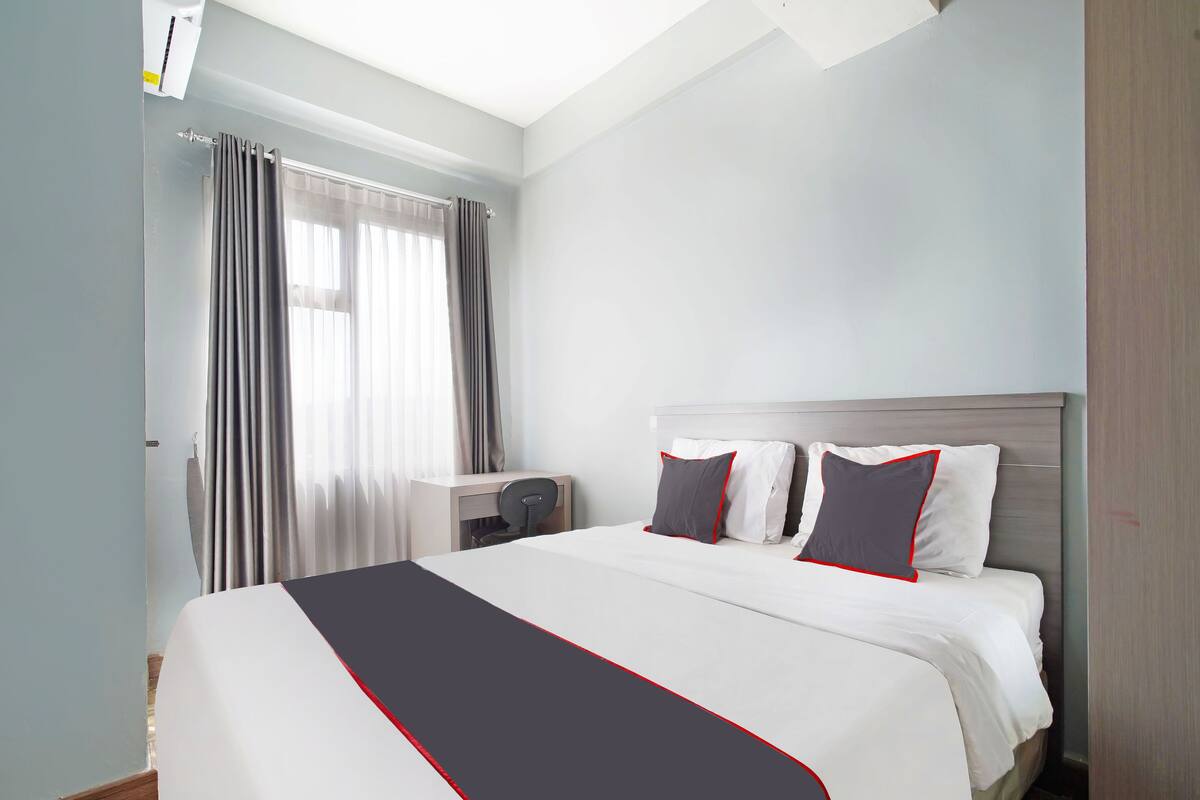 Una habitación de hotel con una cama grande, un escritorio y una silla.