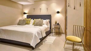 A bedroom with a bed, bedside table, chair, and decorative wall elements.