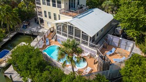 A large two-story house with a swimming pool, multiple decks, and a dock. - Solitude North Captiva, Carts, Dock, Private Pool, Club, Sleeps 12 (Captiva)