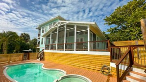 A two-story house with a swimming pool and hot tub on a wooden deck. - Solitude North Captiva, Carts, Dock, Private Pool, Club, Sleeps 12 (Captiva)