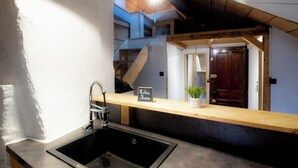 Una cocina con un lavamanos negro, una encimera de madera y un letrero que dice "Lilius Rosa".