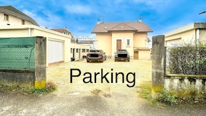 A driveway leading to a house with two cars parked in front. - Leana t2 avec parking (Annecy)