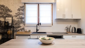 Eine moderne Küche mit einer Holzausziehtheke, einem Spülbecken und einem Fenster darüber.