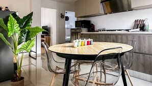 A modern kitchen with a round table, chairs, and a plant. - Marquis proche du centre ville (Annecy)