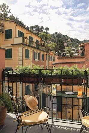 A terrace with a table and chairs, a potted plant, and a view of buildings in the background. - Splendido Mare, A Belmond Hotel, Portofino (Santa Margherita Ligure)
