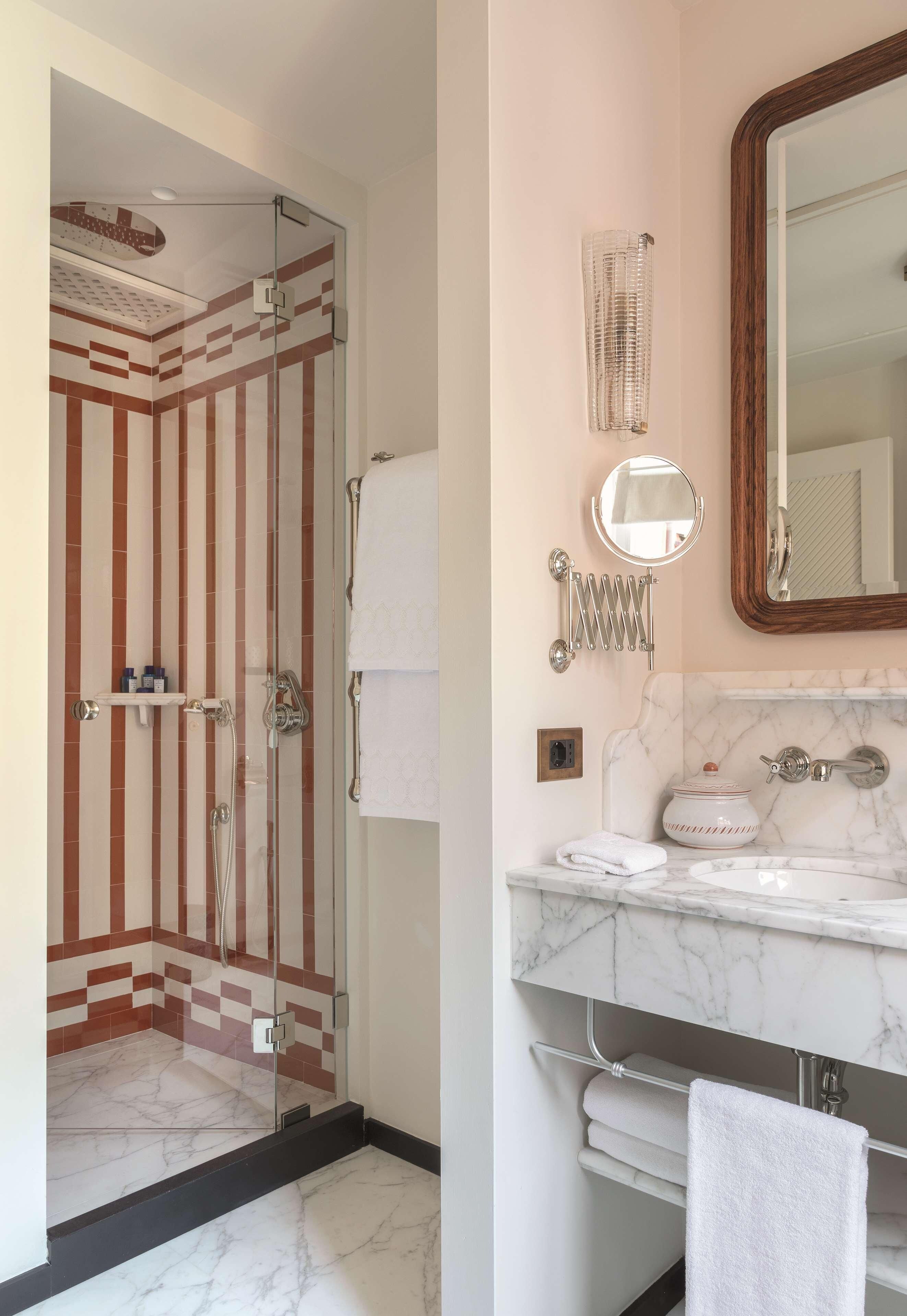 Une salle de bain équipée d’une douche, d’un lavabo, d’un miroir et d’un porte-serviettes.