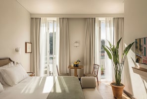 A hotel room with a bed, a small table with a plant, a chair, and a view of the outdoors. - Splendido Mare, A Belmond Hotel, Portofino (Santa Margherita Ligure)