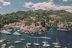 A coastal town with numerous boats docked in a marina, surrounded by lush green hills and historic buildings. - Splendido Mare, A Belmond Hotel, Portofino (Santa Margherita Ligure)