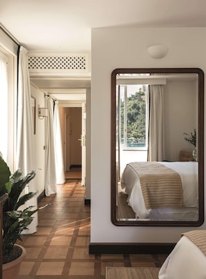 A hotel room with a large mirror reflecting the bed and a view of greenery outside. - Splendido Mare, A Belmond Hotel, Portofino (Santa Margherita Ligure)