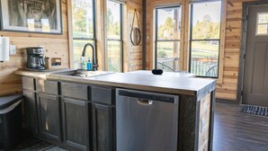 A modern kitchen with a stainless steel dishwasher, a coffee maker, and a sink.