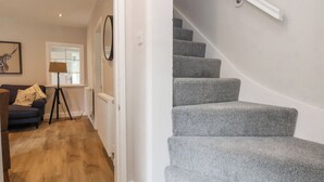 Una escalera con peldaños alfombrados de color gris que conduce a una plataforma.