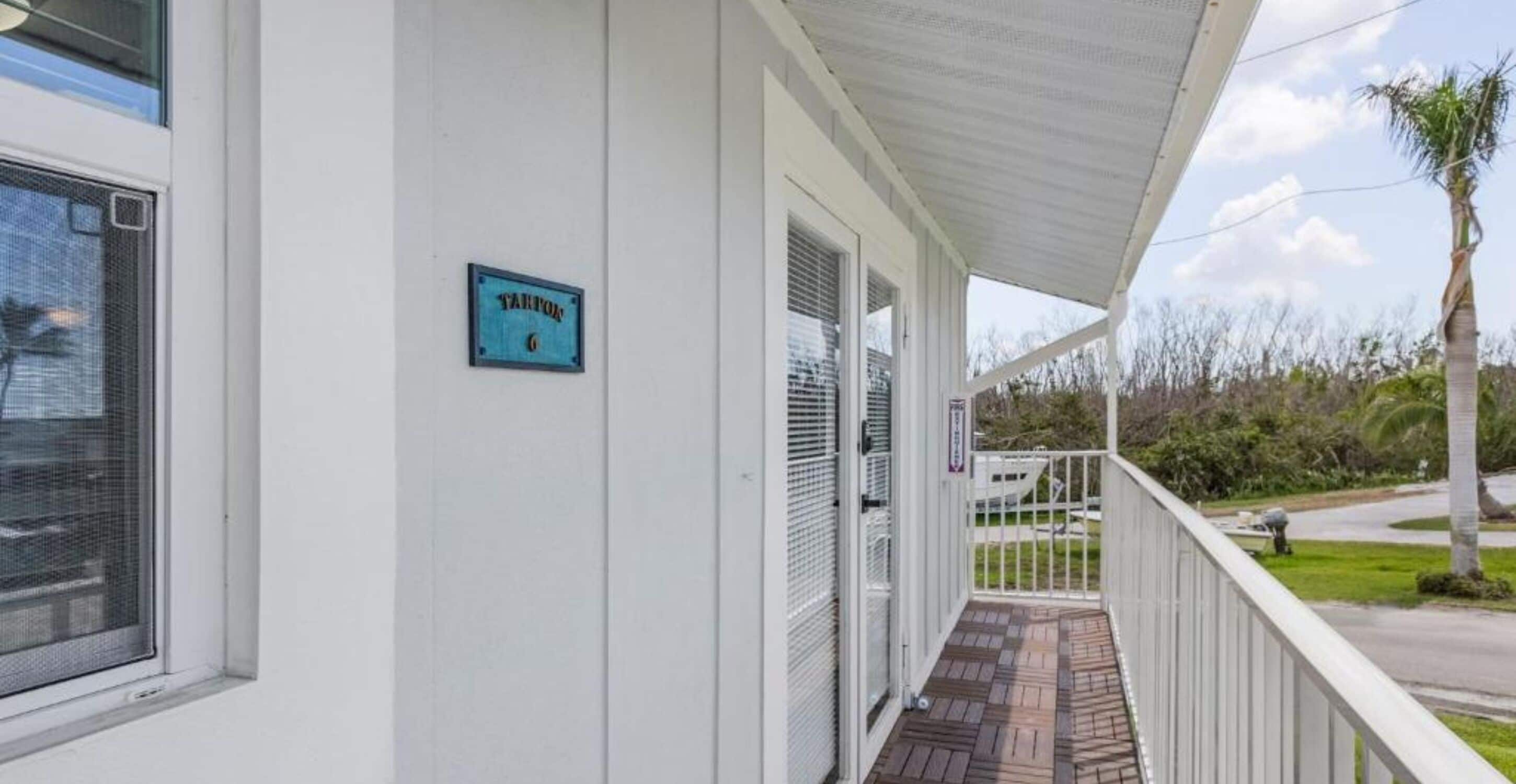Een overdekte veranda met een bordje waarop 