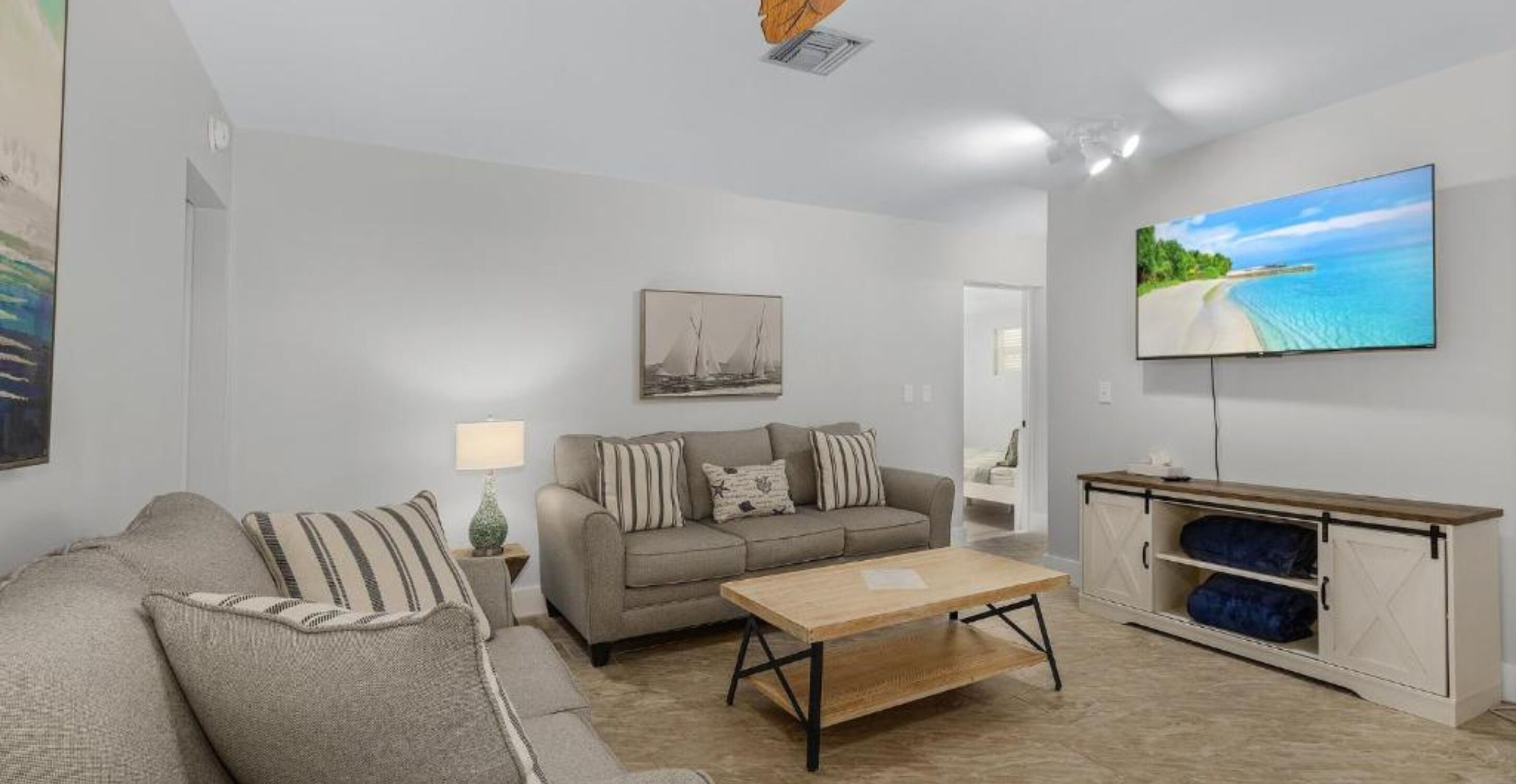 A modern living room with a sofa, a coffee table, a TV, and a cabinet.