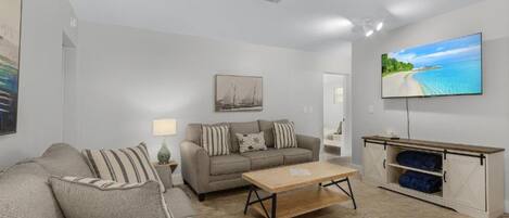 A modern living room with a sofa, a coffee table, a TV, and a cabinet.