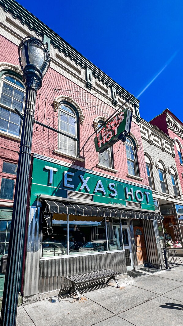 A building with a sign reading "Texas Hot Air Conditioned." - This apartment is located on Main Street in Wellsville NY. (Wellsville)
