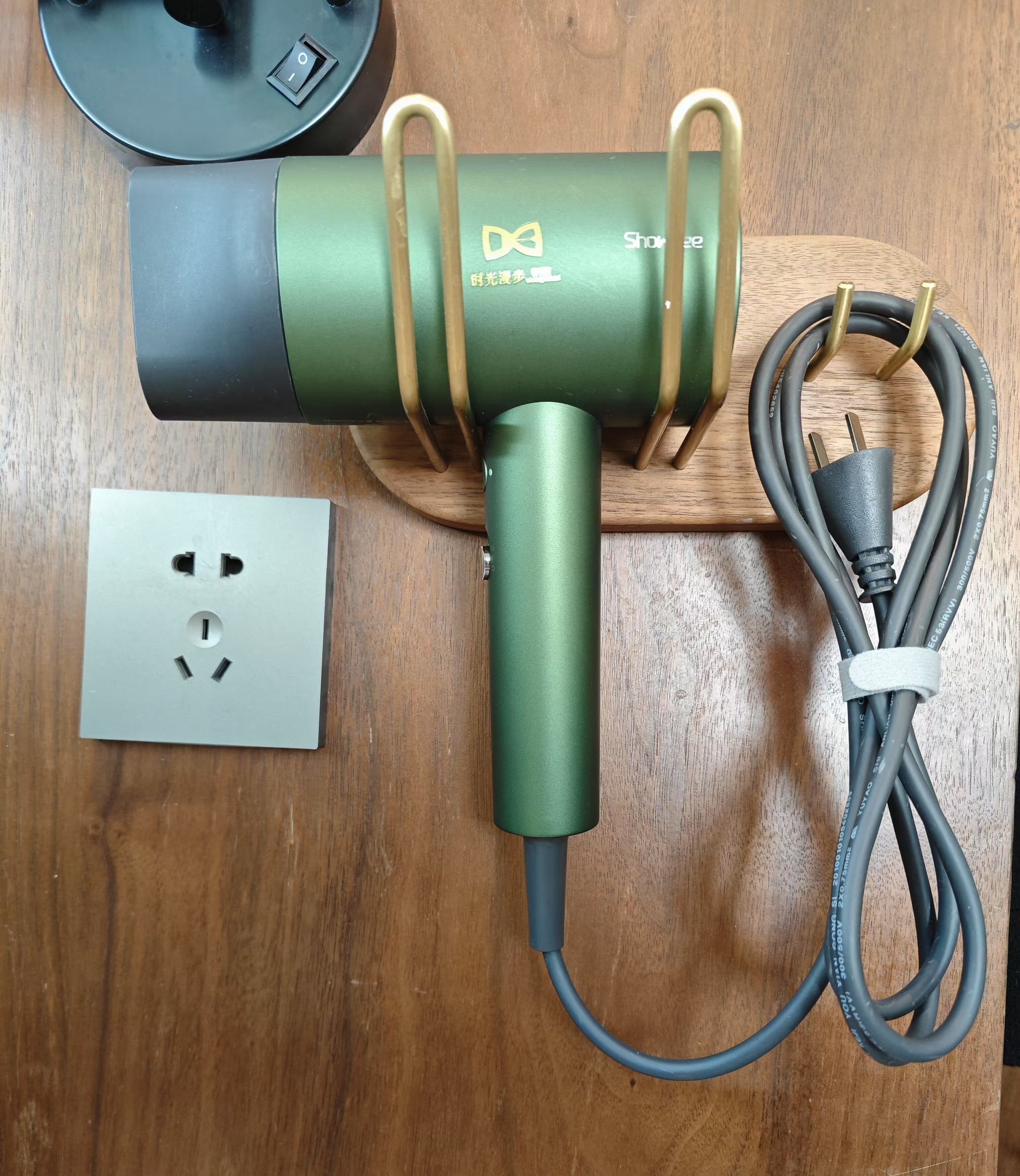 A power strip with multiple outlets and a cable on a wooden surface.