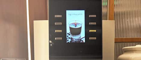 A coffee machine with a digital display, a power outlet, and a coffee pot.