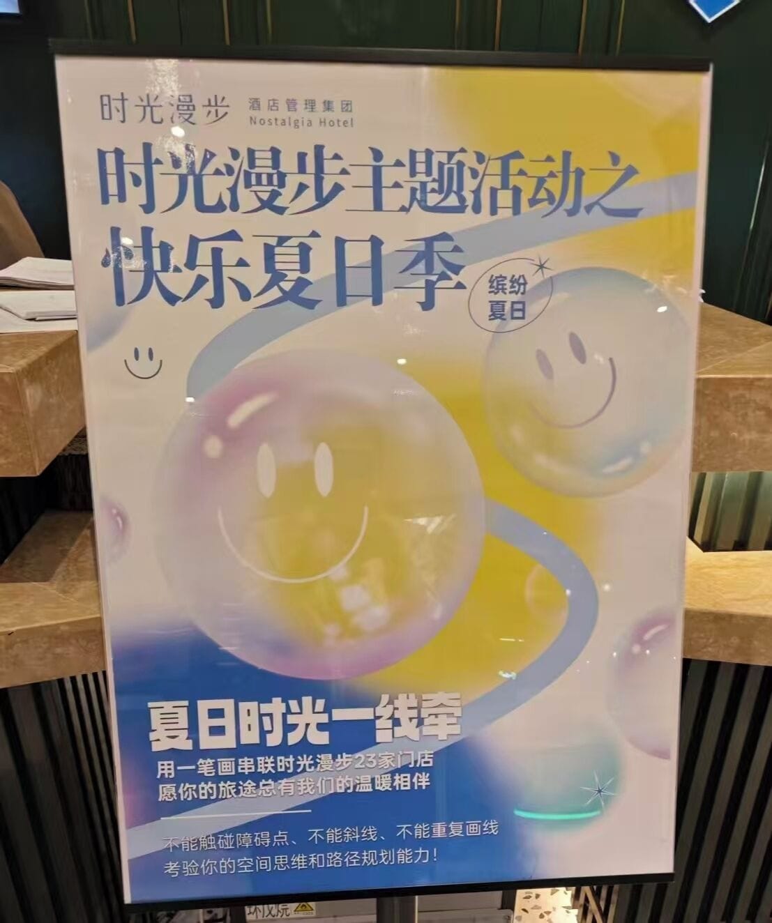 A promotional poster for the Nostalgia Hotel featuring a summer theme with smiley faces and abstract designs.