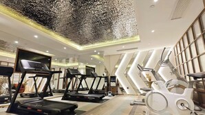 Ein modernes Fitnessstudio mit Laufbändern, Ergometer und einem großen Spiegel.