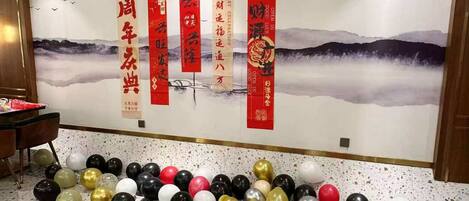 A wall with red banners and a painting of mountains.