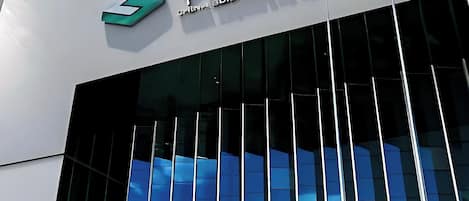 Un edificio moderno con una amplia fachada de vidrio y un cartel que dice