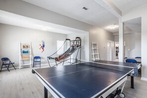 Enjoy games and activities in this room with a ping pong table, shelving unit, and basketball hoop.