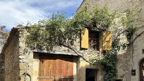 A rustic stone building with a large wooden door and a small window. - La Bergerie (MIRABEL AUX BARONNIES)