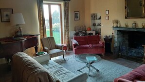 Una sala de estar acogedora con chimenea, un sofá, un sillón y una mesa de centro.