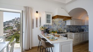 Une cuisine moderne dotée d’un îlot central, d’un coin repas avec vue et d’un balcon.