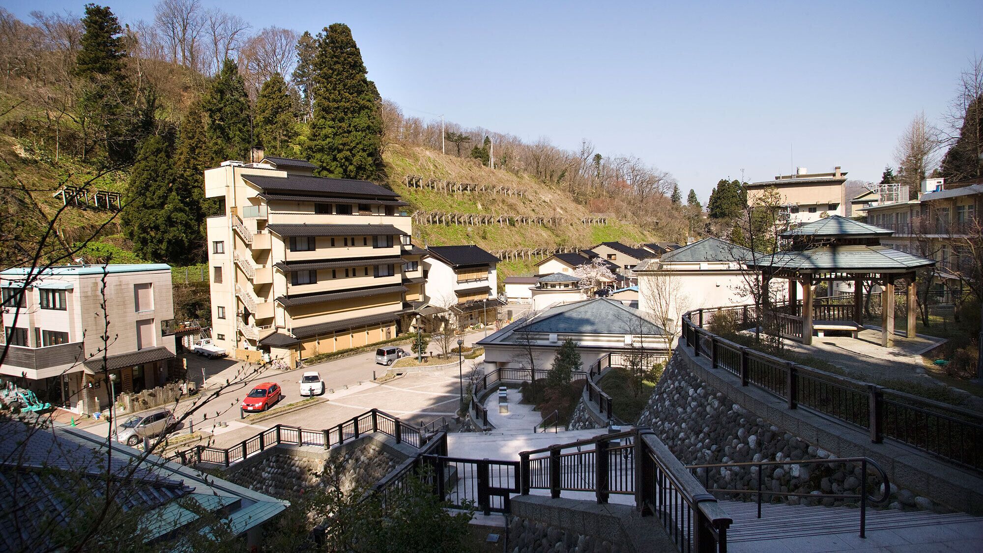 A multi-story building with a traditional architectural style, a stone pathway, and a gazebo.