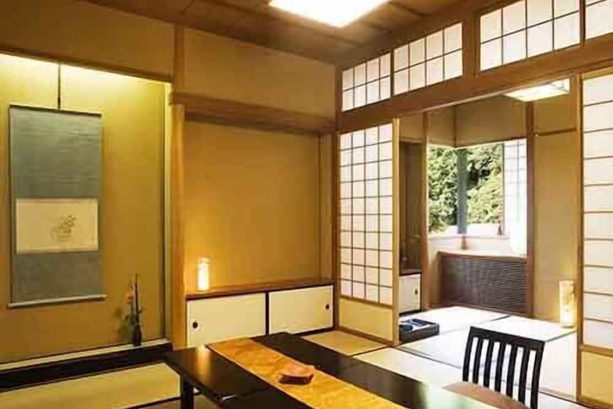 A traditional Japanese room with tatami flooring, a low table, and sliding doors.