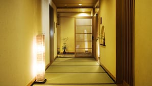 A narrow hallway with tatami mats, a traditional Japanese sliding door, and a small potted plant. - Yuwaku Onsen Sakaeya Ryokan (Kanazawa)
