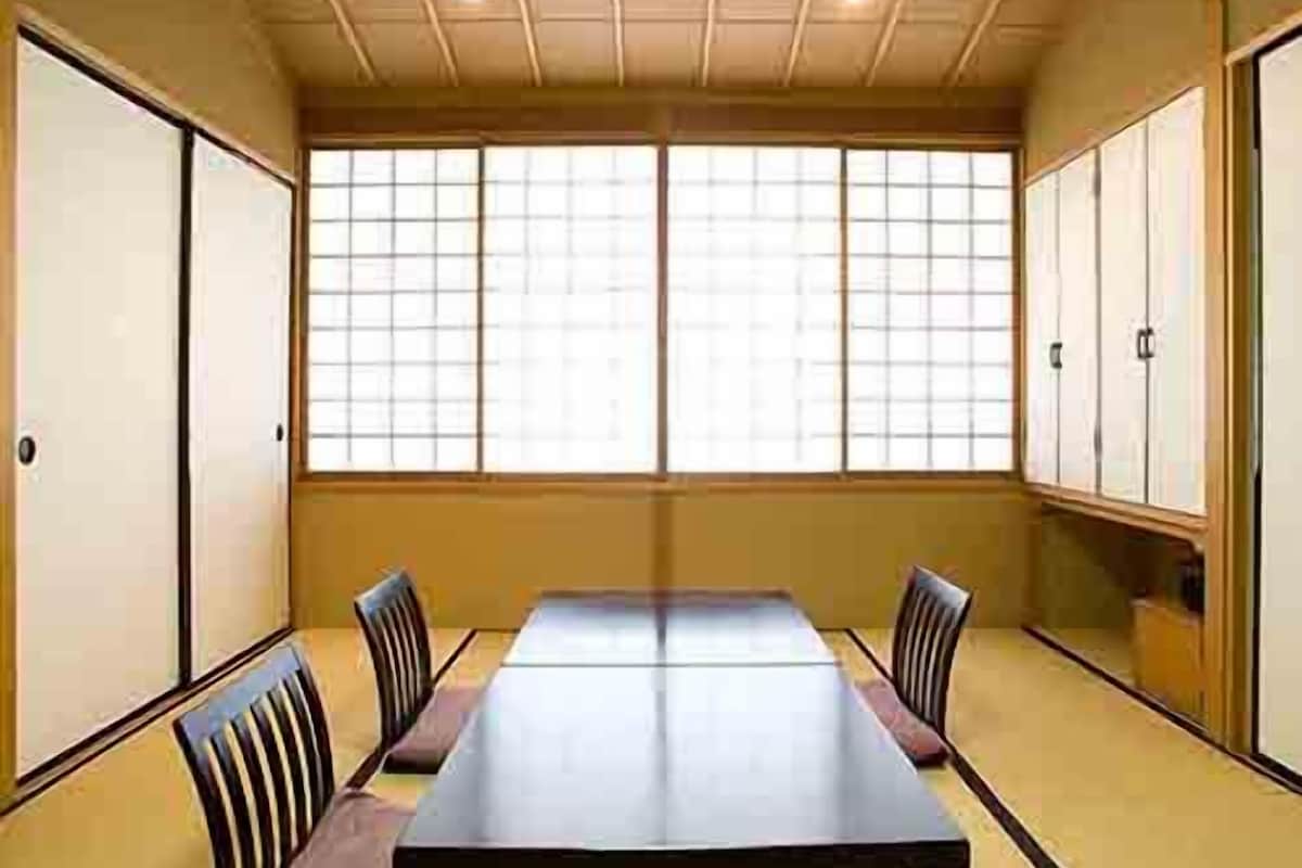 A traditional Japanese room with tatami flooring, a low table, and sliding doors.