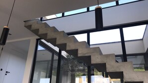 A modern interior with a concrete staircase, large windows, and hanging pendant lights. - VILLA_DE_VACANCES_LA_PINATTE (Saint-Péray)
