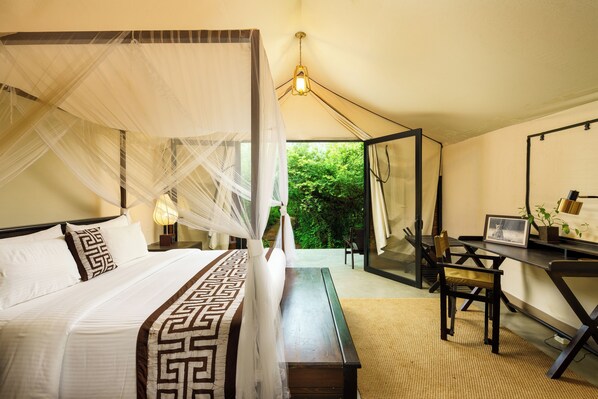 A bedroom with a four-poster bed, a desk, and a chair. - Makini Bush Camp (Kataragama)