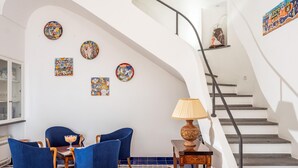 Un coin repas avec des chaises bleues, une table et une lampe.