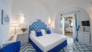 Un dormitorio con una cama grande, paredes blancas y un suelo con estampado azul y blanco en diseño de tablero de ajedrez.