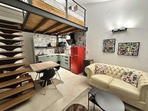 A compact living space with a dining area, kitchenette, and a sofa. - Apartment Urban Green (Porec)