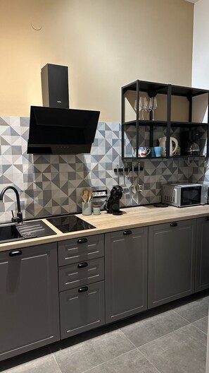 A modern kitchen with a built-in stove, a coffee maker, and a microwave on the counter.