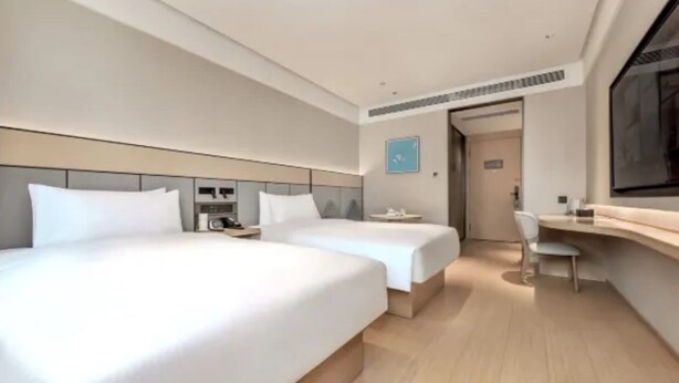 Una habitación de hotel moderna con dos camas, un escritorio y una silla.