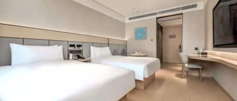 A modern hotel room with two beds, a desk, and a chair.