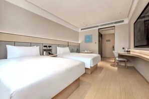 Una habitación de hotel moderna con dos camas, un escritorio y una silla.