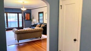 A living room with a beige sofa, a dark-colored couch, and a white door. - Lida's House, Walk to Everything (Arcata)