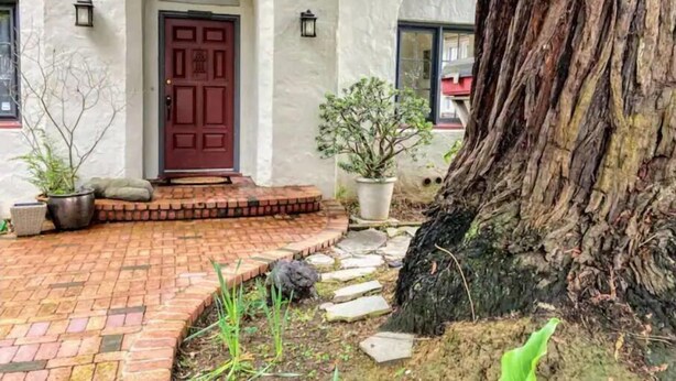 A building with a red door, white walls, and a brick pathway leading to the entrance. - Lida's House, Walk to Everything (Arcata)